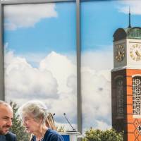 Woman speaking to Jon Lehrer as he leans in to hear her
